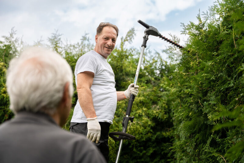 Szene: Mitarbeiter des Seniorenservice beim Heckeschneiden